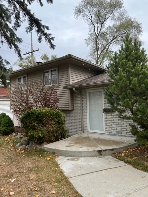 Two-story home with new vinyl siding, brick veneer, and concrete entryway