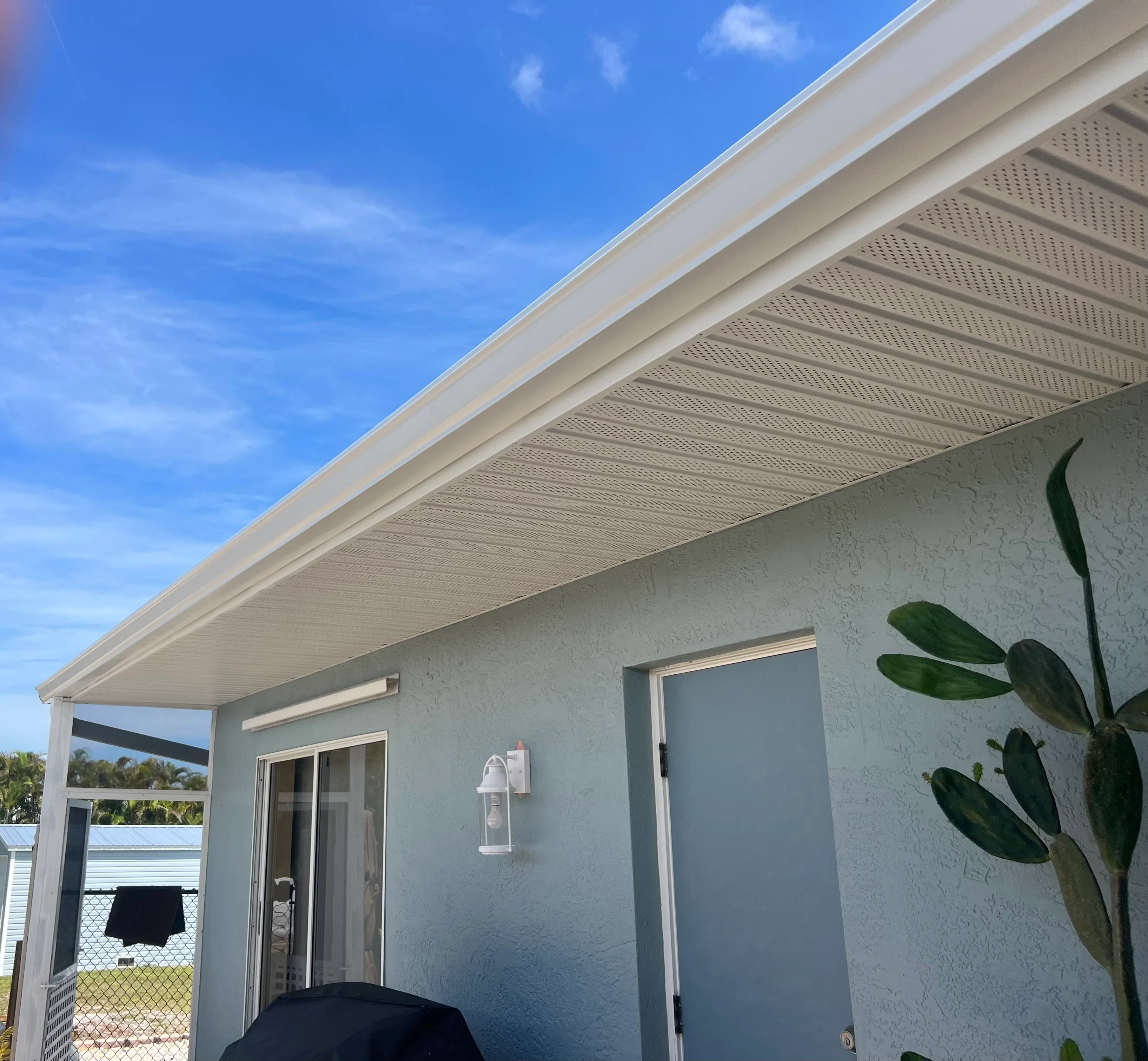 White aluminum patio cover with perforated soffit panels over residential outdoor space