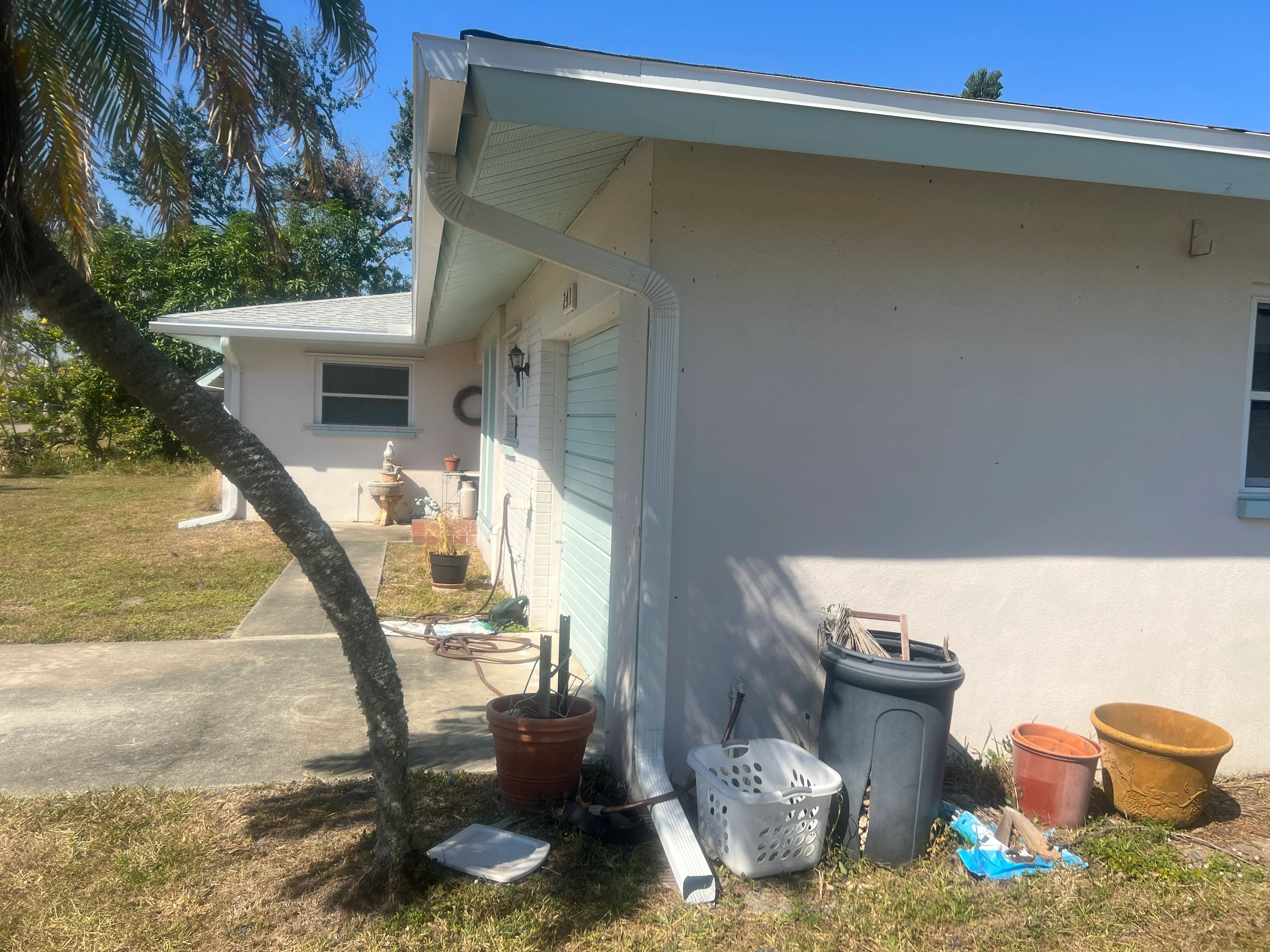 White gutters and soffit installed on residential home exterior with downspout system