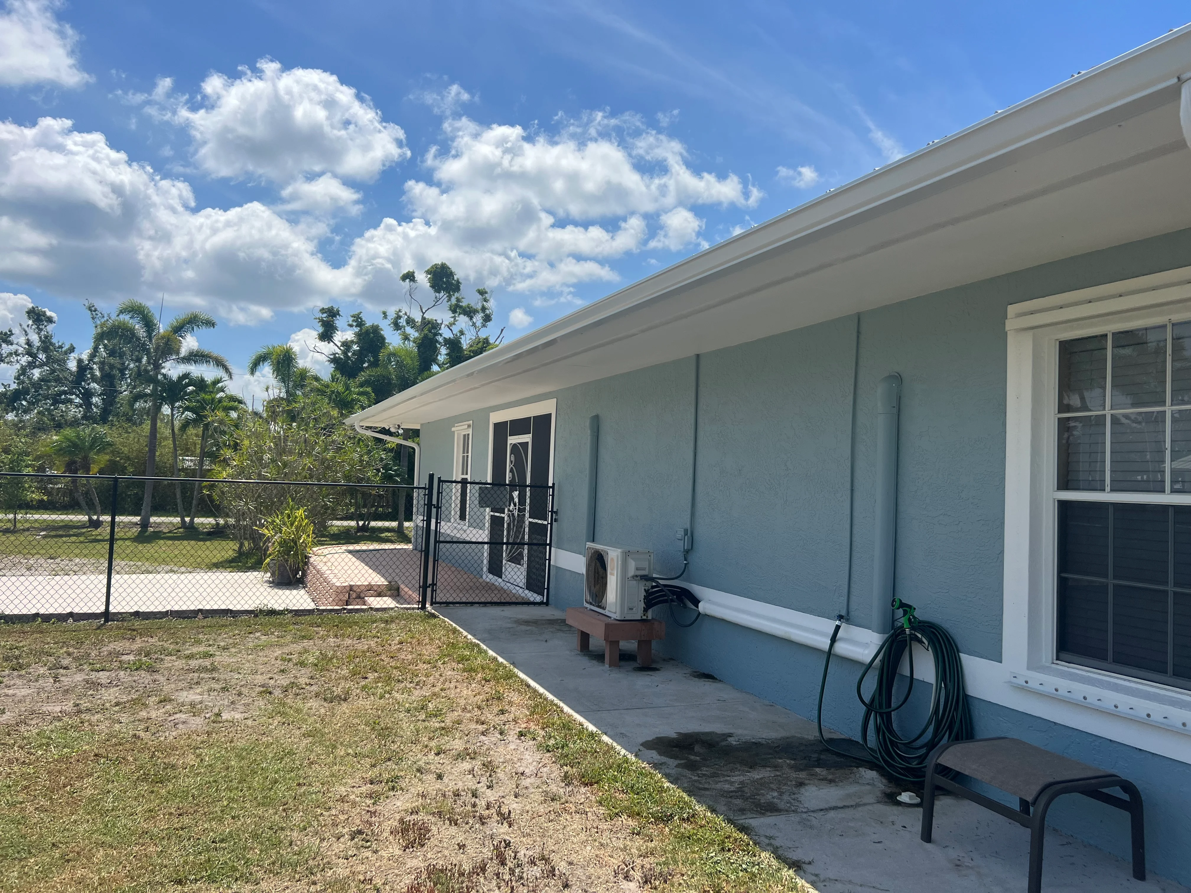 Light blue fiber cement siding with white trim, new sliding glass doors, and white fascia on residential home