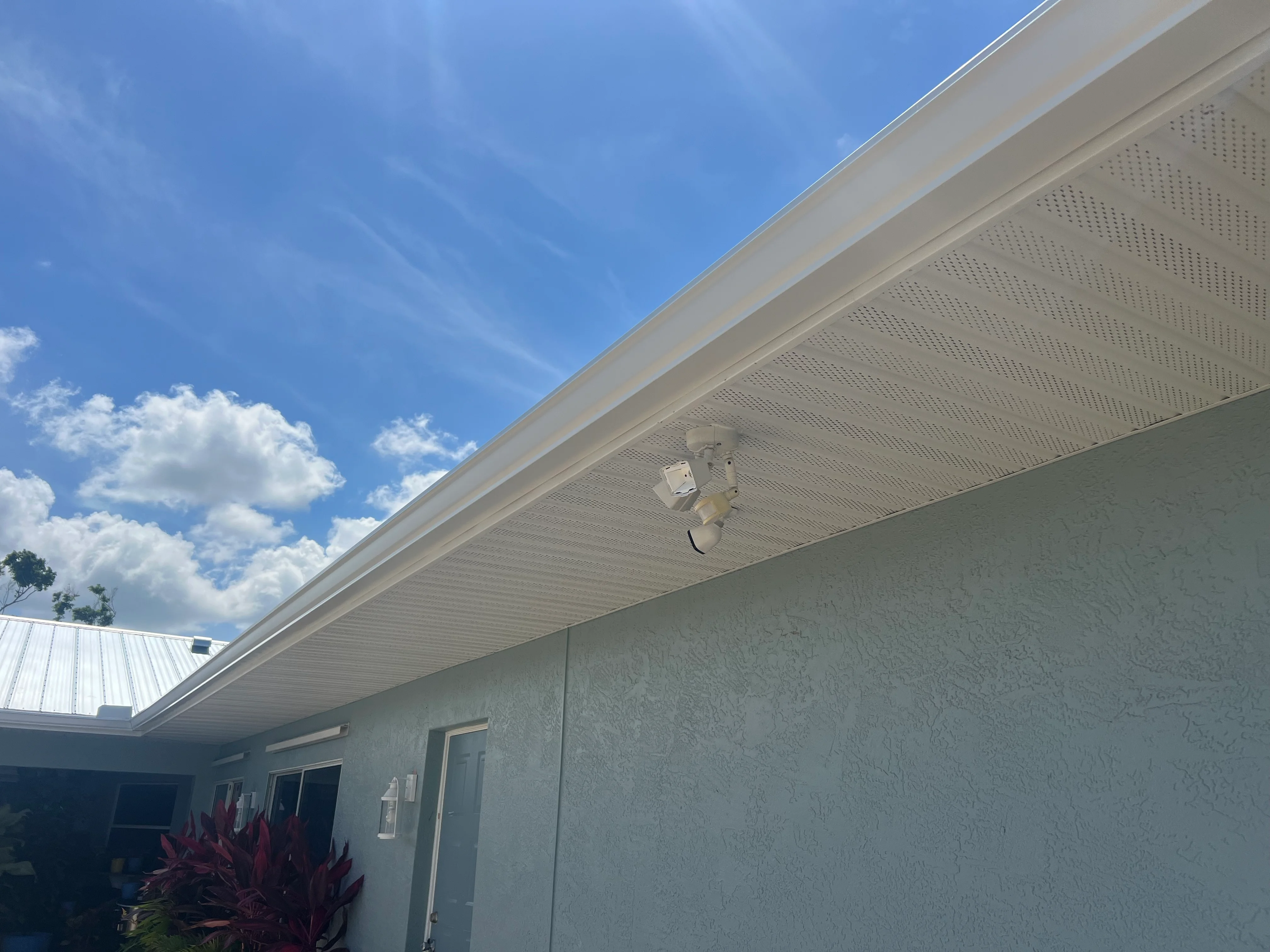 White aluminum soffit and fascia with perforated ventilation panels installed along roofline