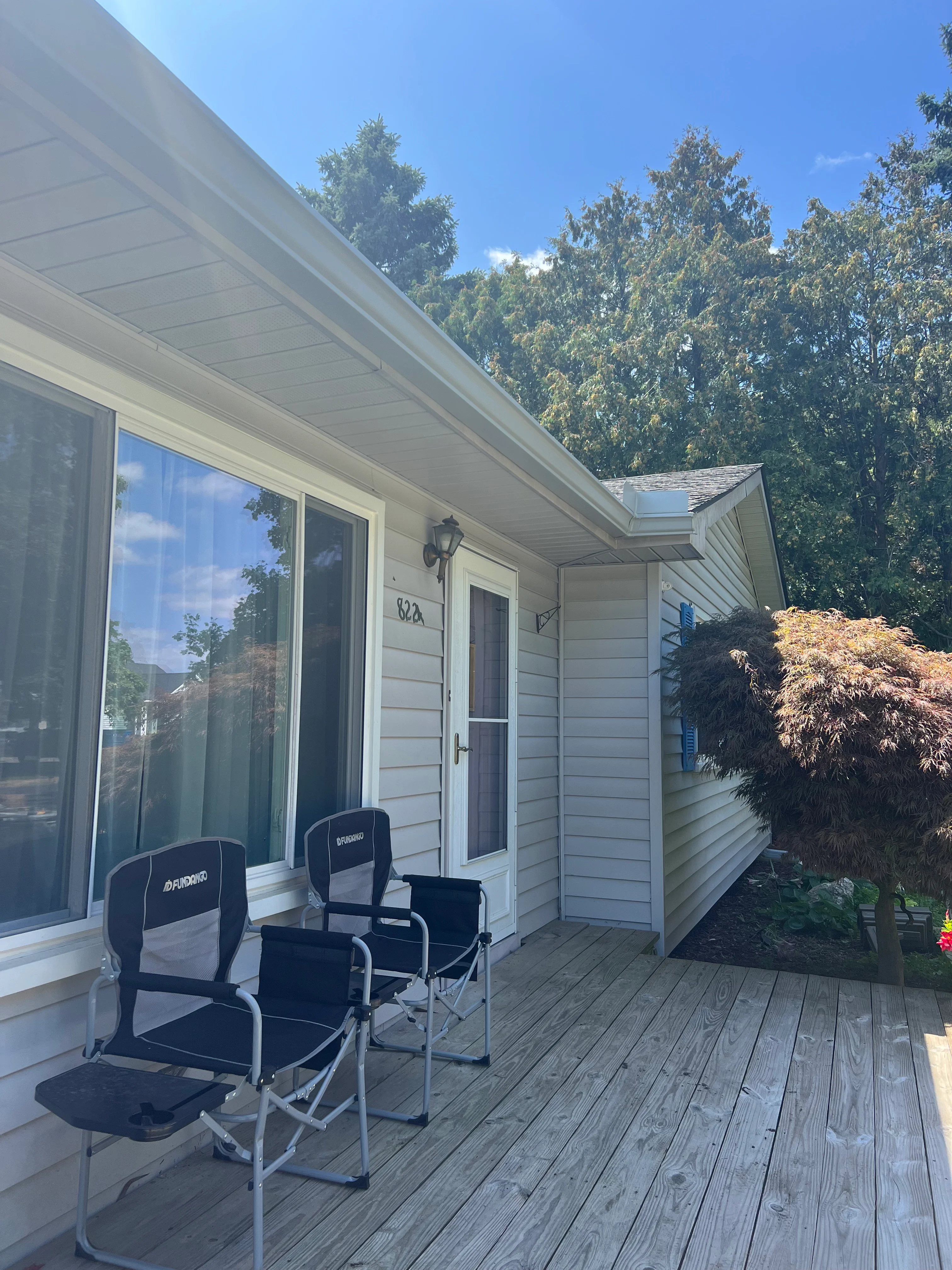 White vinyl siding, soffit, and fascia on residential home with large windows and entry door